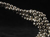 NdFeB magnetic balls on a black background, sticking together and forming a chain